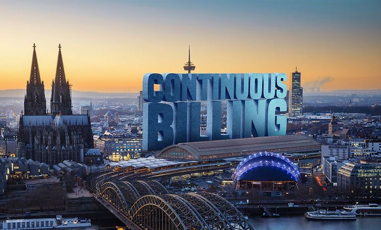 Luftbild von Köln mit Dom und Bahnhof. In der Stadt ein riesiger Schriftzug „Continuous Billing“.