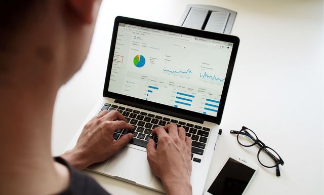 Blick über die Schulter eines Mannes, der am Laptop arbeitet.