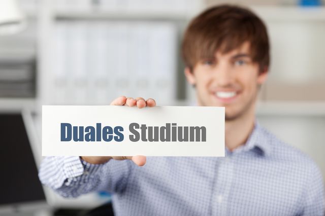 Student hält Schild 'Duales Studium' nach vorn